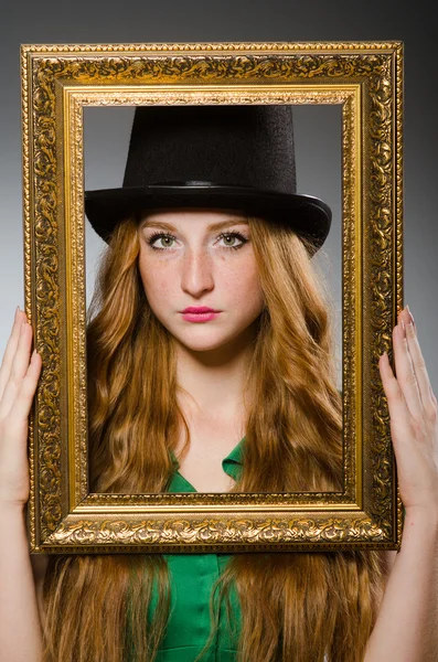 Woman wearing green dress holding picture frame — Stock Photo, Image