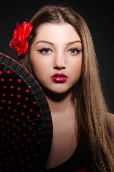 Beautiful young woman with flower and fan — Stock Photo, Image