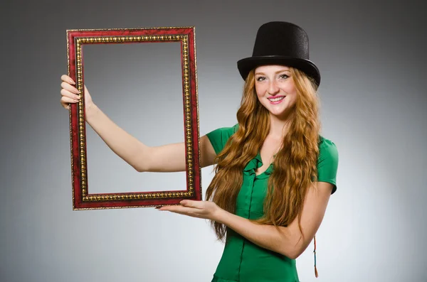 Woman wearing green dress holding picture frame — Stock Photo, Image