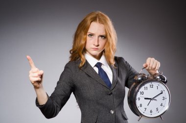 Çalar saat işaret ile genç güzel iş kadını