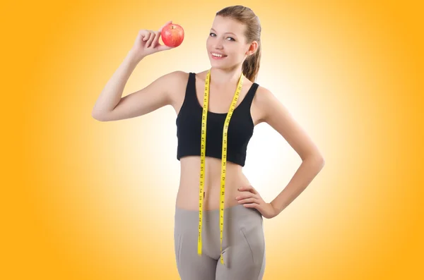 Woman with apple doing exercises — Stock Photo, Image