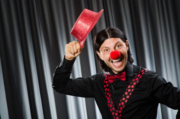 Vtipný klaun v humorném pojetí proti oponě — Stock fotografie