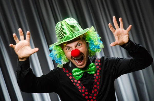 Clown divertente nel concetto umoristico contro tenda — Foto Stock