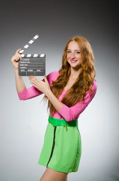 Woman in colourful dress holding movie board — Stock Photo, Image