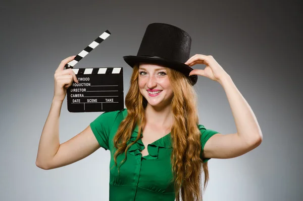 Vrouw draagt groene jurk met filmbord — Stockfoto