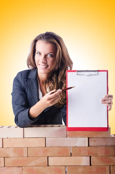 Mujer constructora y pared de ladrillo — Foto de Stock