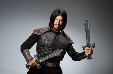 Karanlık arka planda kılıçlı kızgın bir şövalye