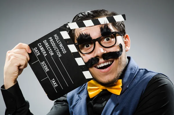 Zabawny człowiek trzymający klaskanie w kinie — Zdjęcie stockowe