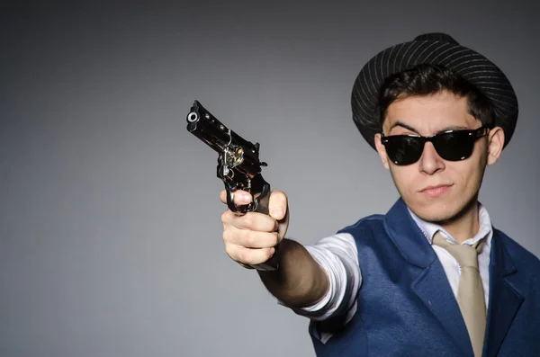 Een man met een zonnebril en een pistool — Stockfoto