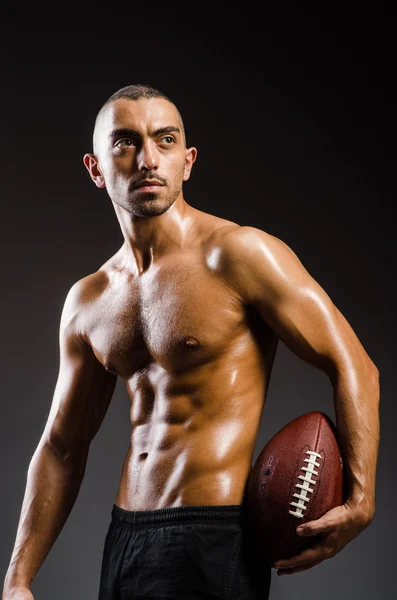 Muscular football player with ball — Stock Photo, Image