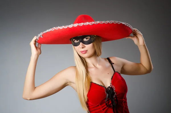 Woman wearing red sombrero and mask — Stock Photo, Image