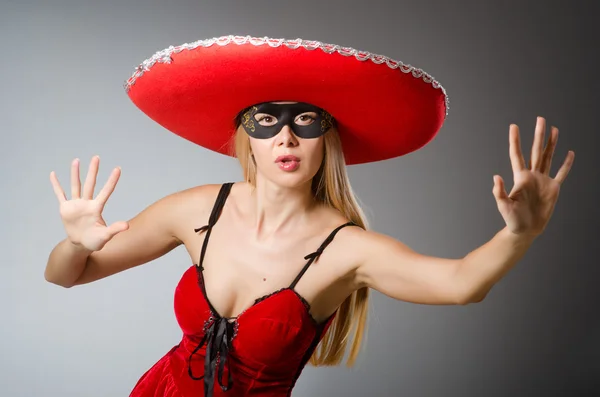 Woman wearing red sombrero and mask — Stock Photo, Image
