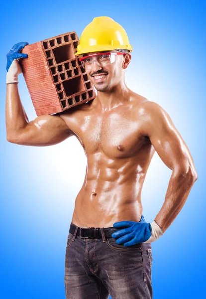 Construtor muscular com tijolos — Fotografia de Stock