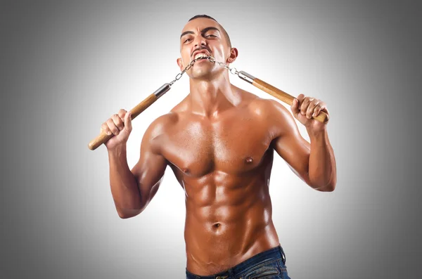 Man in martial met nunchucks — Stockfoto