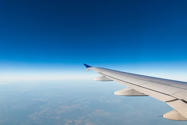 Flygplansvingen ut genom fönstret — Stockfoto