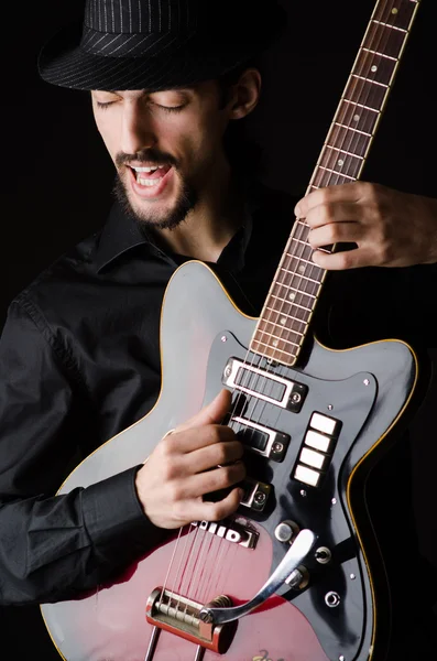 Человек с гитарой во время концерта — стоковое фото