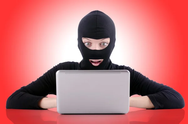 Hacker with computer wearing balaclava — Stock Photo, Image