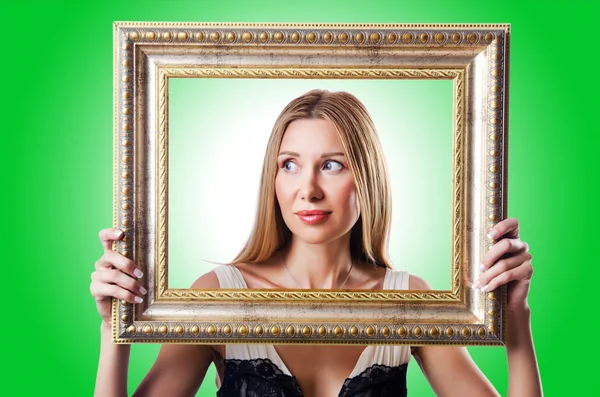 Woman with picture frames on green — Stock Photo, Image