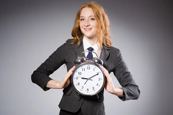 Businesswoman with clock on gray — Stock Photo, Image