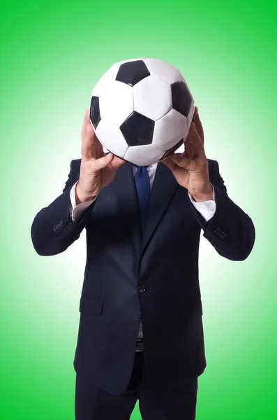 Бізнесмен з футболом на зеленому — стокове фото