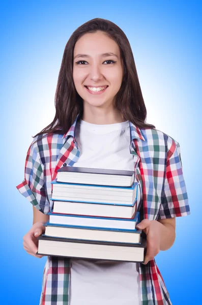 Studente ragazza con molti libri contro il gradiente — Foto Stock