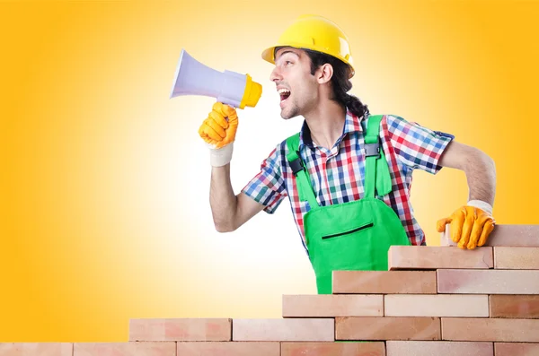 Construtor e tijolos contra o gradiente — Fotografia de Stock