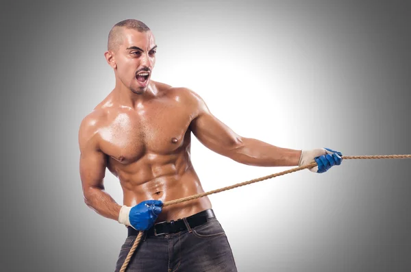 Muskularny mężczyzna ciągnięcie liny — Zdjęcie stockowe