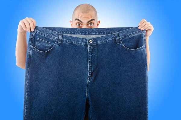 Mannen i bantning koncept med överdimensionerade jeans — Stockfoto