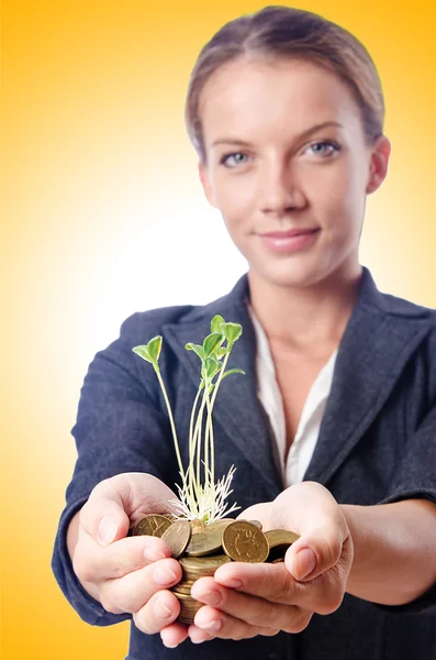 Businesswoman with seedlings and coins — Stock Photo, Image