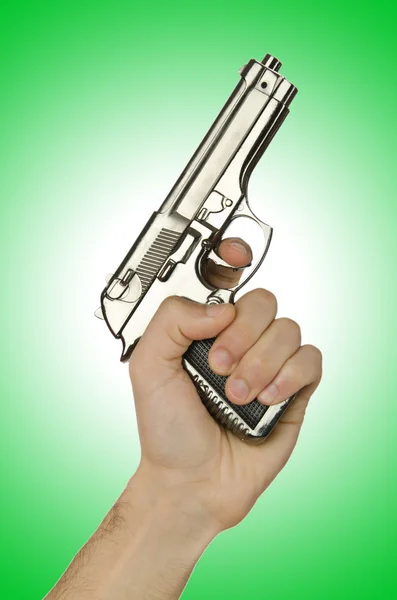Zbraň v ruce na zelené — Stock fotografie