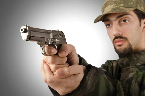 Soldat med pistol isolerade på grå — Stockfoto