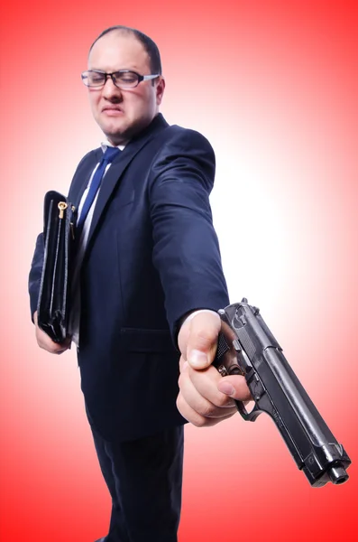 Homme d'affaires avec pistolet sur rouge — Photo