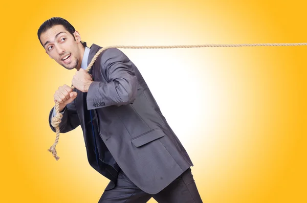 Businessman pulling rope against the gradient — Stok fotoğraf