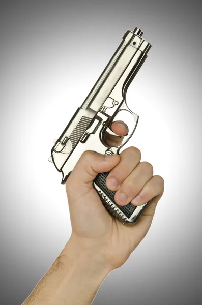 Пистолет в руке против градиента — стоковое фото