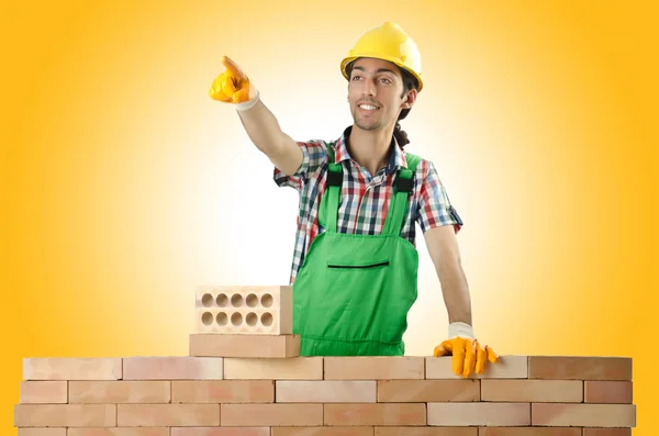 Builder and bricks against the gradient — Stock Photo, Image