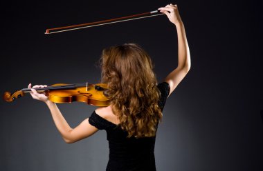 Female musical player against dark background clipart