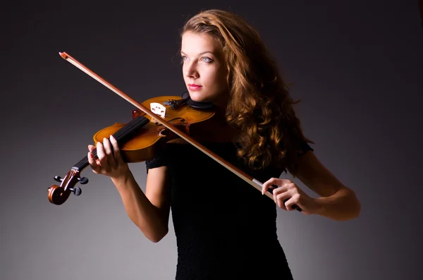 Female musical player against dark background — Stock Photo, Image