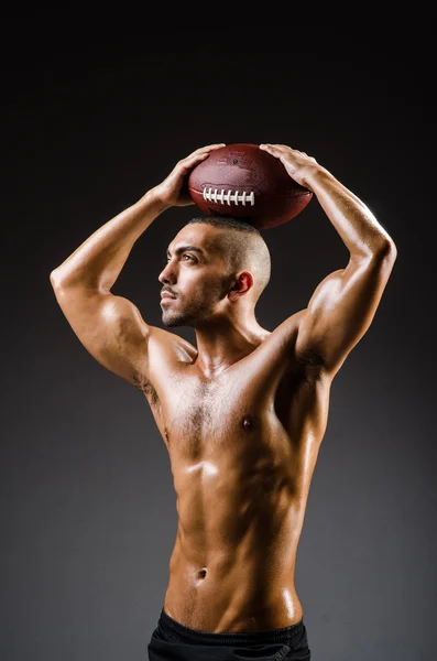 Muscular football player with ball — Stock Photo, Image