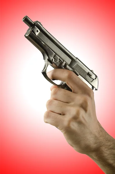 Arma na mão contra o gradiente — Fotografia de Stock