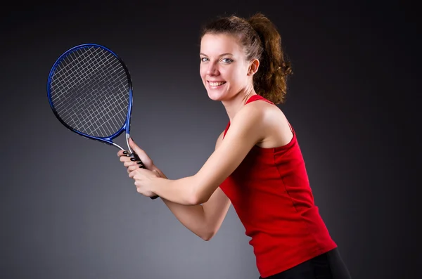 Woman tennis player against dark background — Stock Photo, Image