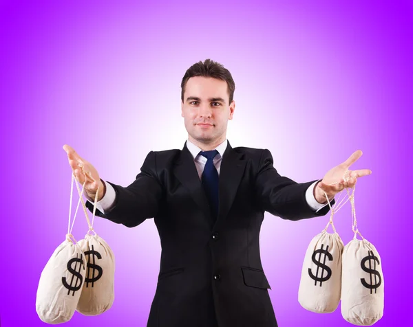 Az ember a pénzt zsákokban ellen a színátmenet — Stock Fotó