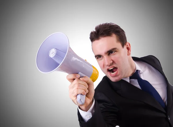 Young businessman with loudspeaker against the gradient — Stock Photo, Image