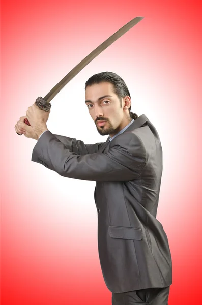 Businessman with sword  against the gradient — Stock Photo, Image