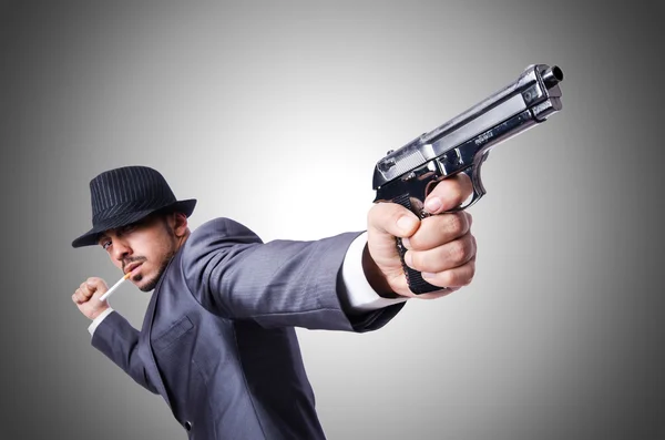 Бизнесмен с пистолетом против градиента — стоковое фото