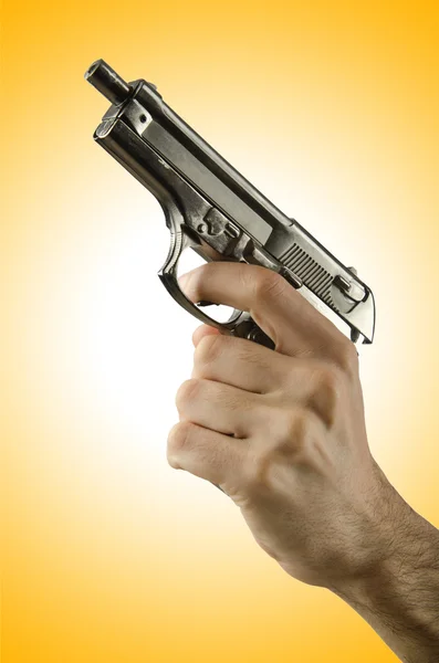 Pistola en la mano contra el gradiente — Foto de Stock