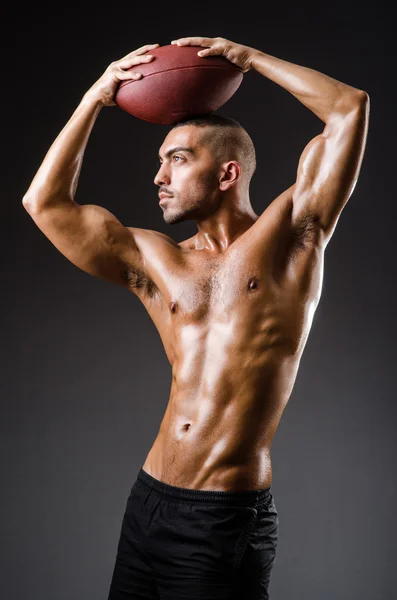Muskulös fotbollspelare med boll — Stockfoto