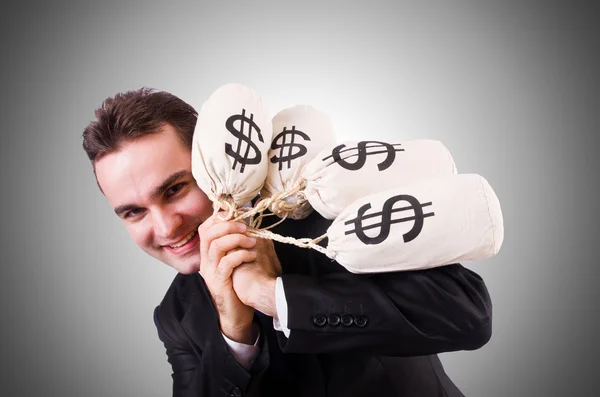 Homem com sacos de dinheiro contra o gradiente — Fotografia de Stock