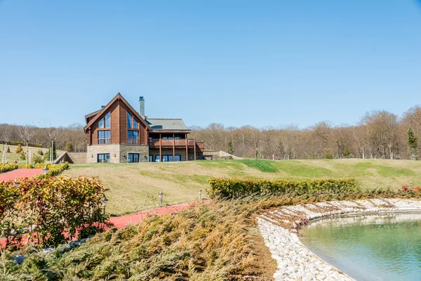 Modern house near water on bright day — Stock Photo, Image