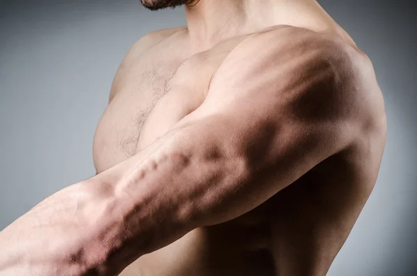 Hombre musculoso posando en estudio oscuro — Foto de Stock