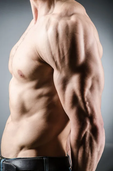 Homem muscular posando em estúdio escuro — Fotografia de Stock